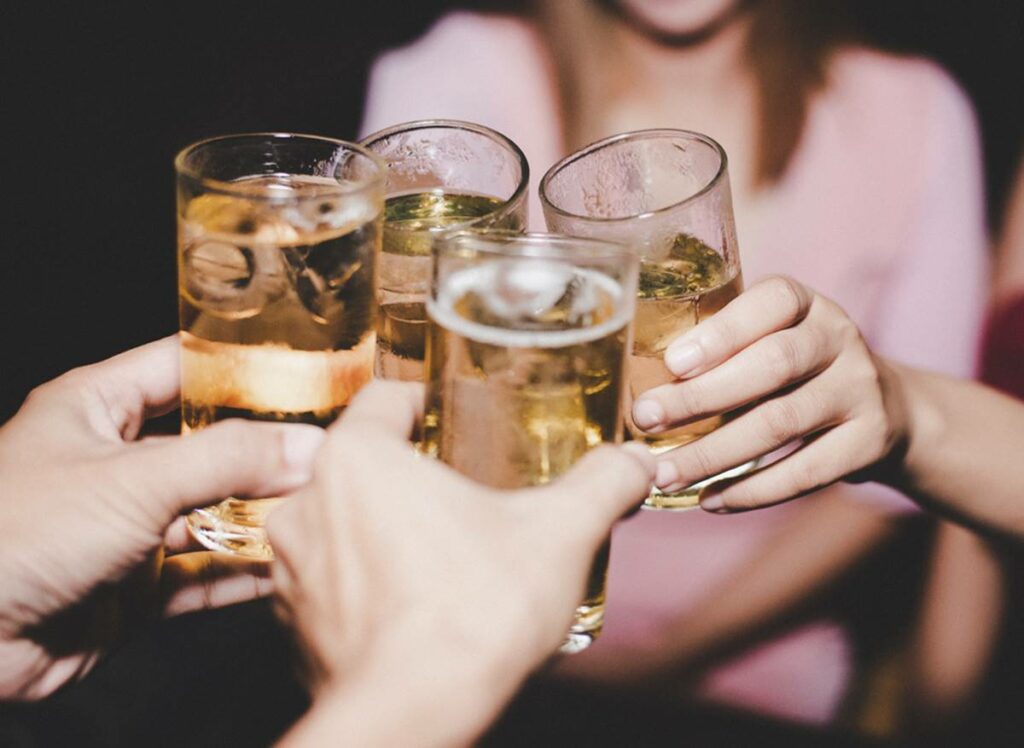 Female Friends with glass beer At Party