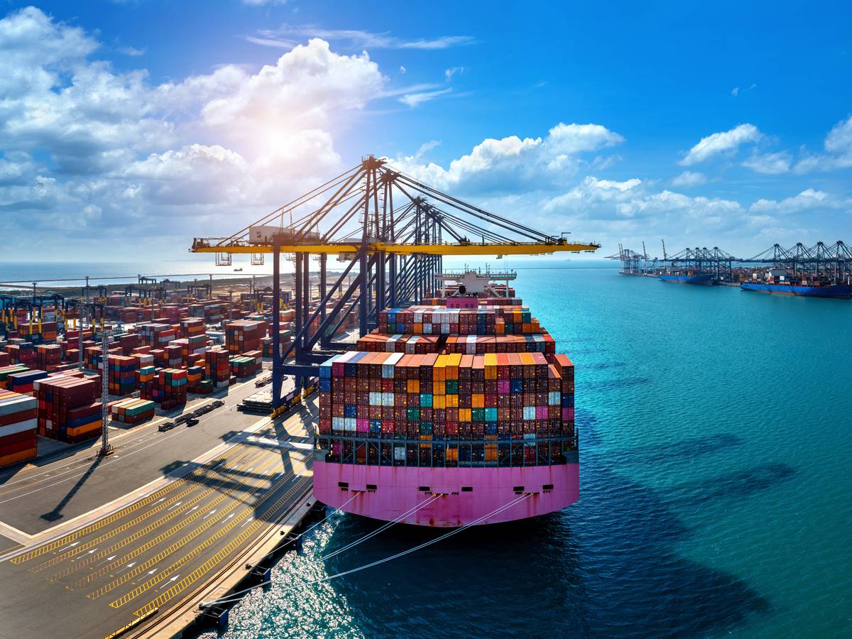 Aerial view of cargo ship and cargo container in harbor.