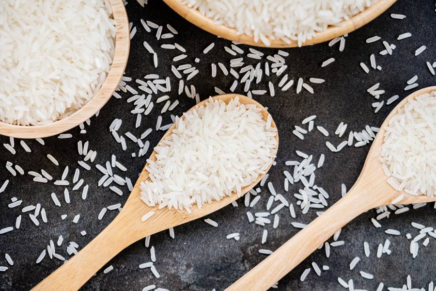 Raw Jasmine rice in wooden bowl  and spoon with grain and seed