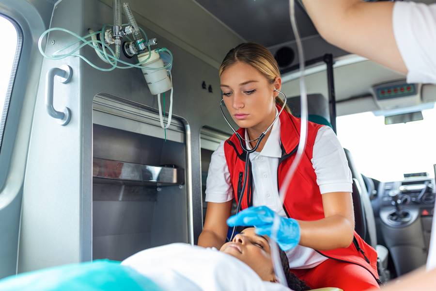 Doctors emergency or paramedics are working with a senior woman patient while he lies on a stretcher in an ambulance.