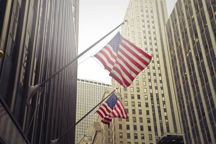 A shot of two American or US flags on a high rise building