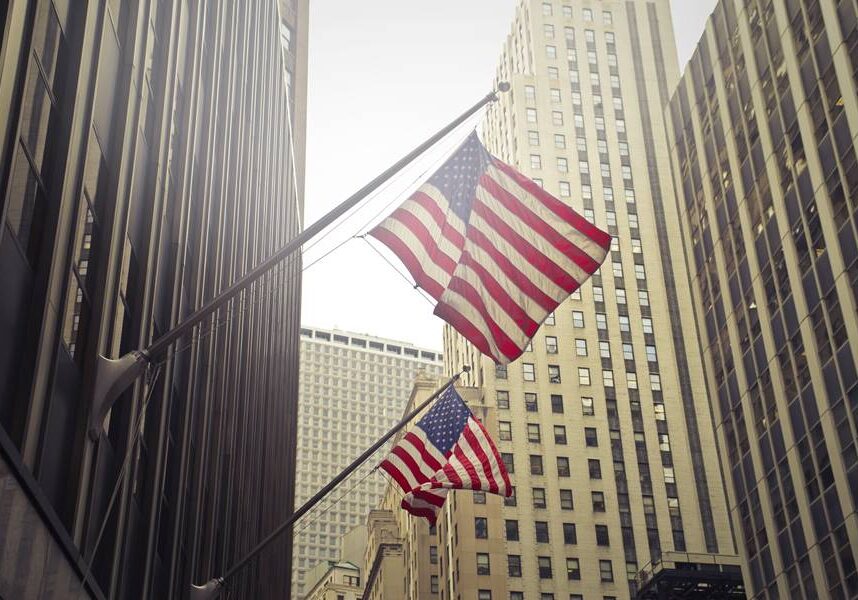 A shot of two American or US flags on a high rise building