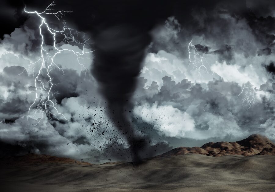 Silhouette of a man stood in the desert in the middle of a storm with tornado and lightning