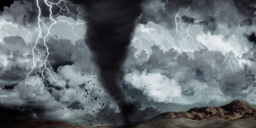 Silhouette of a man stood in the desert in the middle of a storm with tornado and lightning